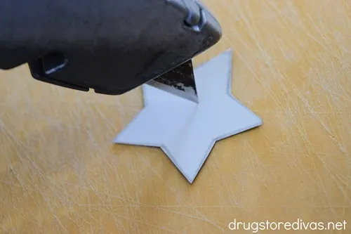 An X-Acto knife blade on top of a white cardboard star.
