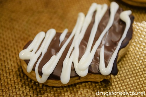 White zigzag lines on a chocolate-covered heart shaped cookie.