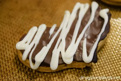 White zigzag lines on a chocolate-covered heart shaped cookie.