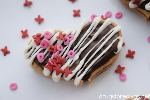 A decorated Nutter Butter Cookie Heart on a white tray with red and pink XO sprinkles around it.