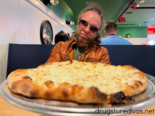 A man wearing sunglasses looking at a pizza in Ponysaurus Brewing in Wilmington.