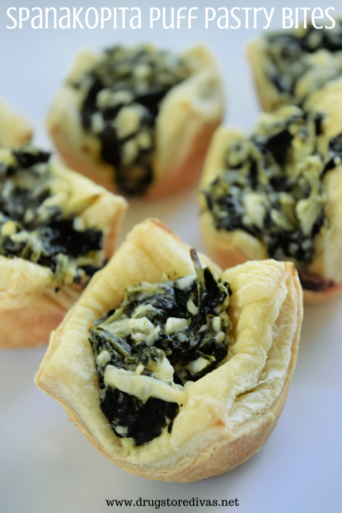 Five puff pastry cups with spinach and feta in them and the words "Spanakopita Puff Pastry Bites" digitally written on top.