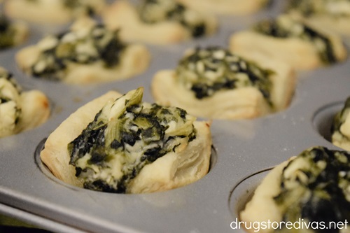 Baked spanakopita puff pastry bites in a muffin pan.