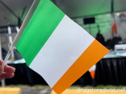 A handheld Irish flag in front of a stage.
