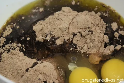 Brownie mix and two eggs in a white bowl.