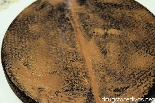 A round brownie with a crumb coat on it.