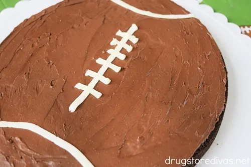 A football-shaped brownie on a white scalloped plate.