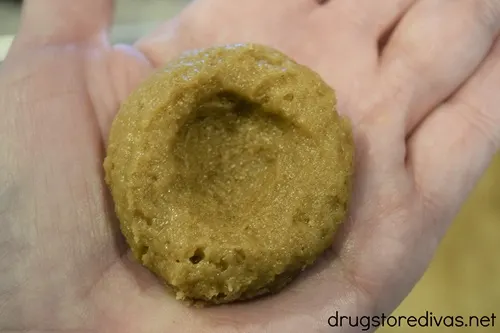 A dough ball with a well in it in the palm of a hand.