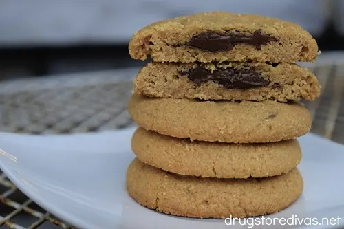 Five Nutella-stuffed peanut butter cookies stacked on top of each other with the top two cut open to show chocolate inside.