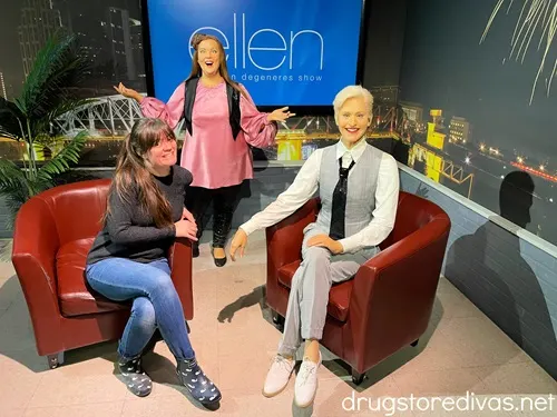 A woman sitting on the set of the Ellen show with two wax figures the Hollywood Wax Museum in Myrtle Beach, SC.
