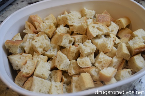 Cubed bread in a white casserole pan.
