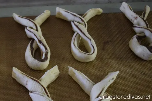 Unbaked puff pastry bunnies on a baking sheet.