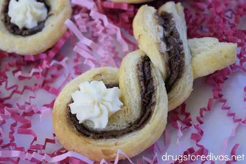 Puff Pastry Easter Bunnies on a white tray with pink paper shred.