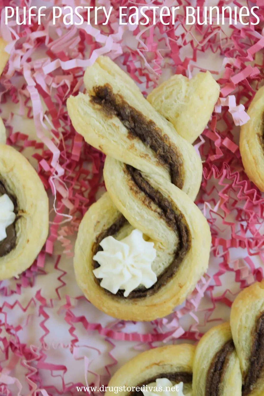 Four cookies that look like the backs of bunnies on pink paper shred with the words 