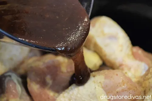 Barbecue sauce being poured over chicken.