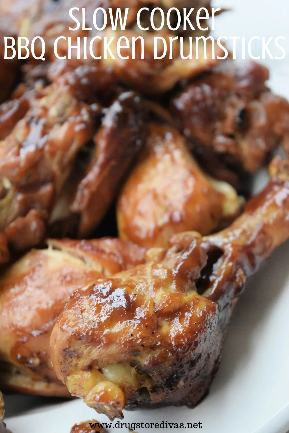 Chicken drumsticks on a white plate with the words 