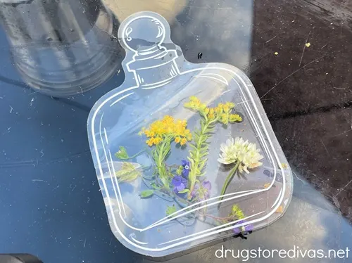 A clear plastic apothecary jar sticker filled with tiny flowers.