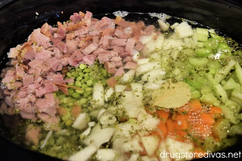 Diced ham, dried peas, chopped carrots, celery, onion, and seasoning in a slow cooker with water on top.