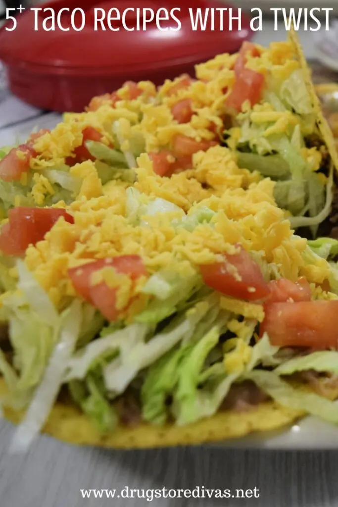 A plate of tacos with lettuce, tomato, and cheese on top and the words "5+ Taco Recipes With A Twist" digitally written on top.