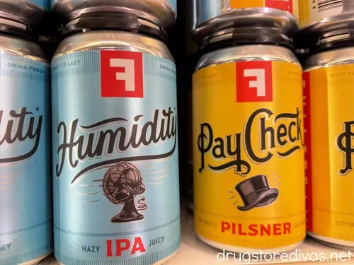 Four cans of Fullsteam brewery beer. The blue cans on the left are called Humidity and the two orange cans on the right say PayCheck.