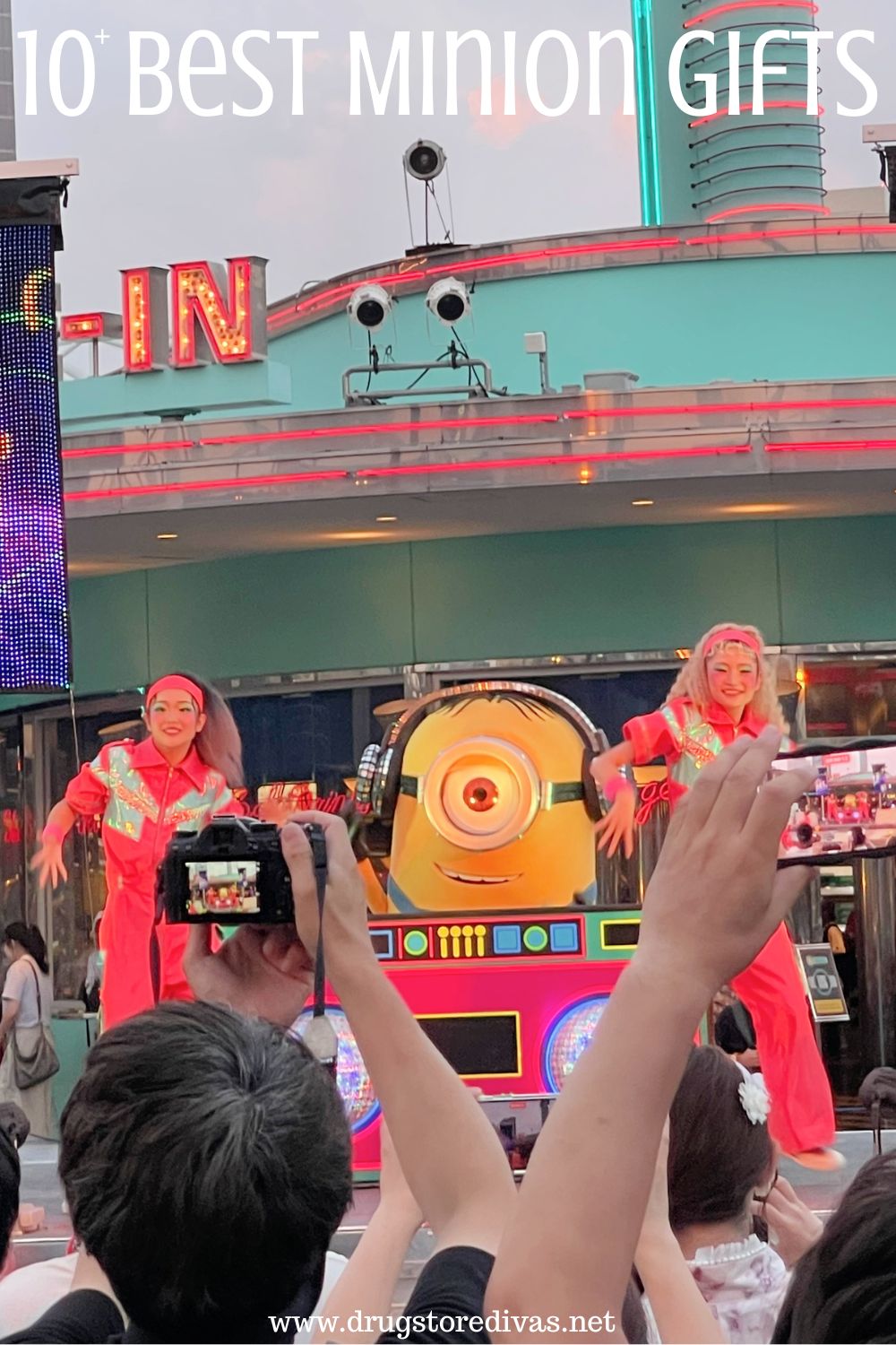 A Minion DJing on a stage with a dancer on each side and the words 