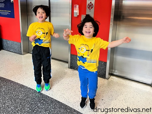 Two boys in Minions shirts standing in front of an elevator.