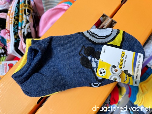 A pair of blue socks in a pack of Minions socks.