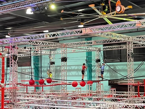 Three boys on the ropes course at OC Aerial, a ninja warrior gym in Durham, North Carolina.