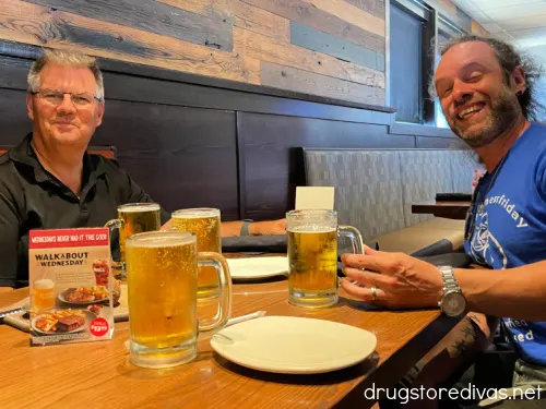 Two men sitting at a table with beer at an Outback Steakhouse.