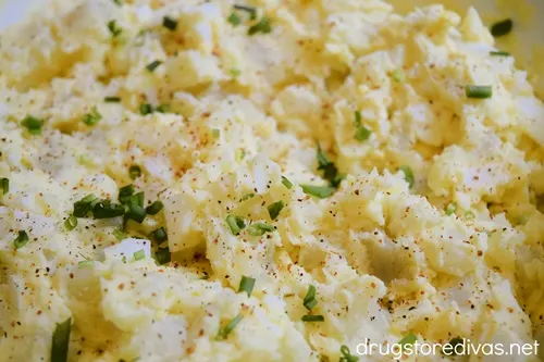 Deviled egg potato salad with green onions and Tajin seasoning on top.