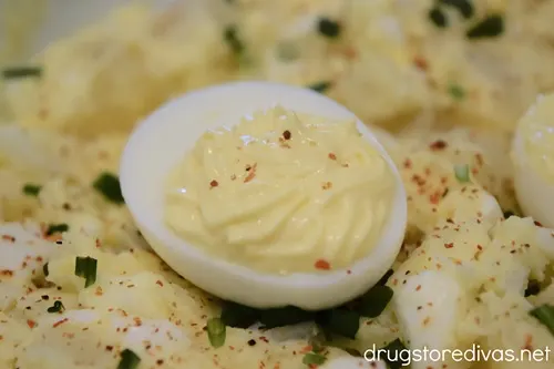 A deviled egg on top of a bowl of deviled egg potato salad.