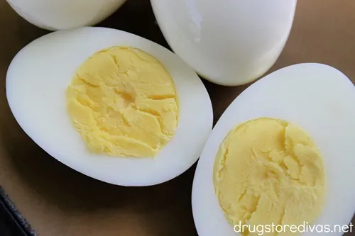 Three hard boiled eggs with one cut open.