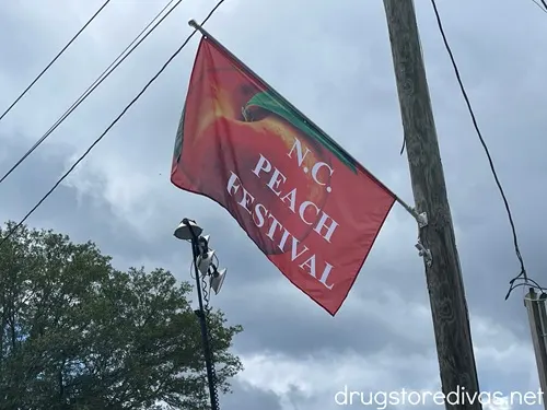 A flag on a pole advertising the NC Peach Festival in Candor, NC.