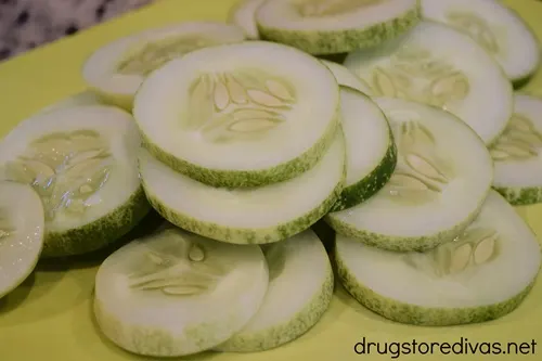 Cucumber slices on a yellow green cutting board.