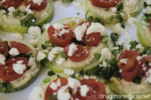 Cucumber hummus bites on a white serving tray.