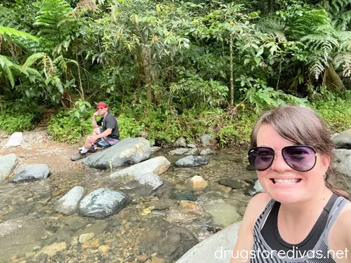 A woman and man sitting on rocks at the Angelito Trail in El Yunque National Forest.