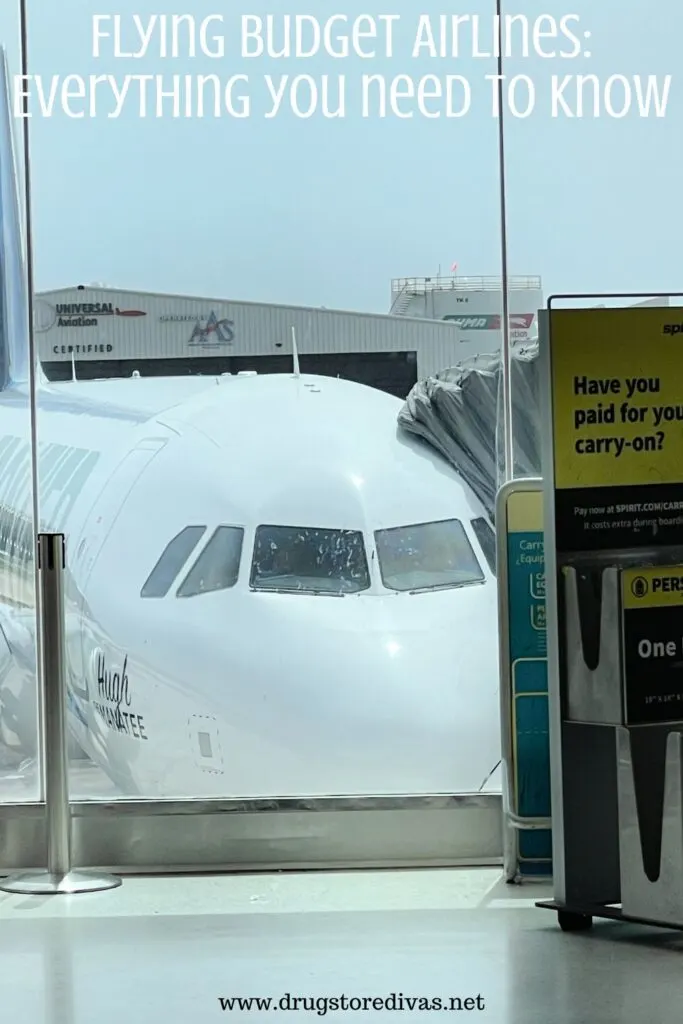 An airplane waiting at a gate with a sign about paying for luggage next to it and the words "Flying Budget Airlines: Everything you need to know" digitally written above it.