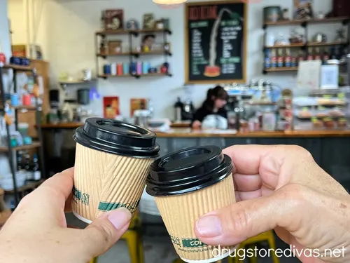Two tiny sample cups of coffee being cheered together.