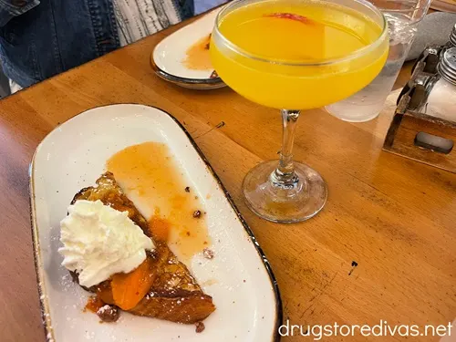 French toast and a peach martini on a table.
