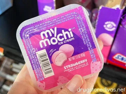 A hand holding a small pack of My Mochi ice cream.