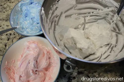 Red meringue, blue meringue, and white meringue in three bowls.
