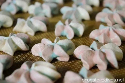 Red, white, and blue meringue cookies on a silicone baking mat.