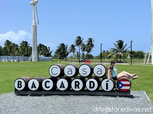 A woman sitting on barrels that spell out CASA BACARDI.