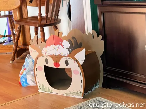 A Christmas-themed cardboard cat house.