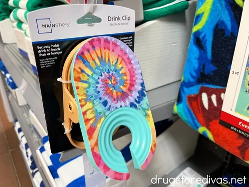 A tie dyed drink clip holder in the package at a store.
