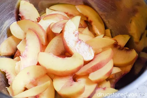 Peach slices in a silver bowl.