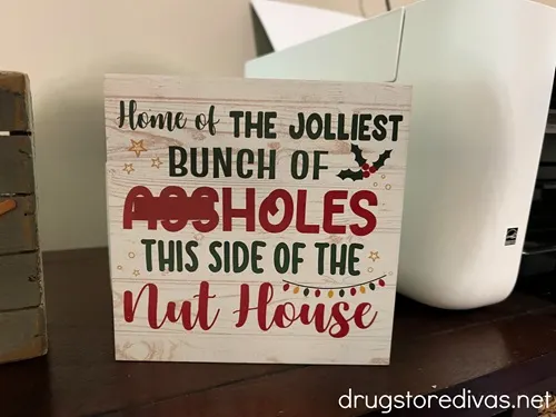 A sign that says "Home of the jolliest bunch of ***holes this side of the nut house."