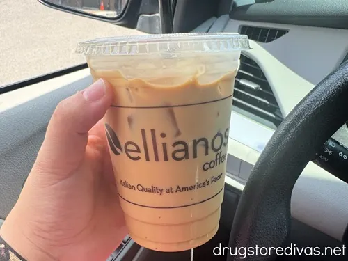 A hand holding an iced coffee cup that says Elliano's Coffee on it.