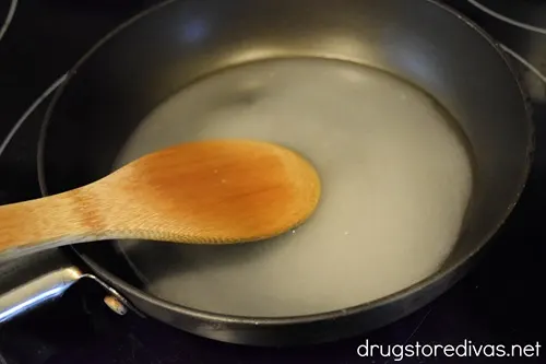 A bamboo stirring sugar water in a pan.