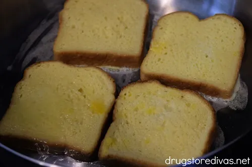 Four pieces of egg washed bread in a pan.